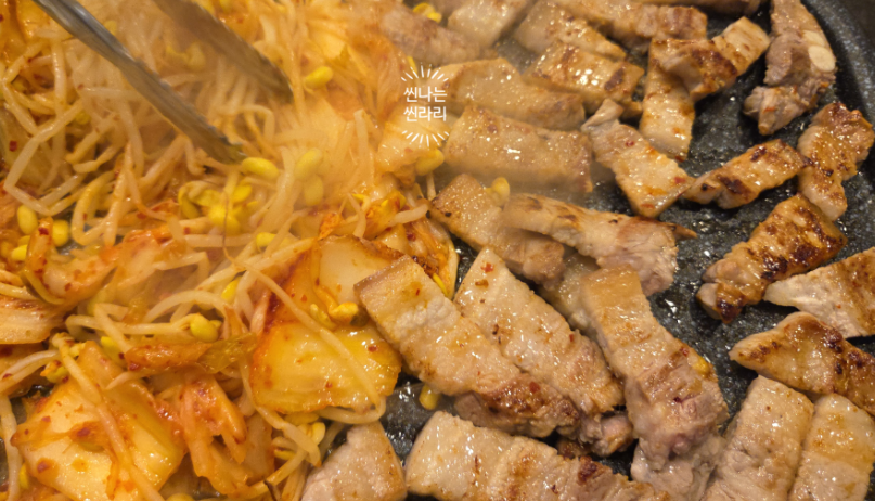 Grilling pork belly with kimchi at the restaurant Dwaejine in Nakseongdae, Korea