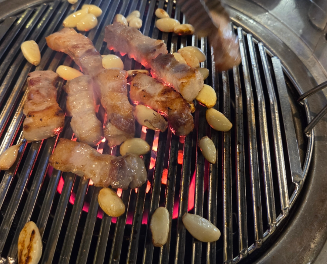 Korean pork belly or pork belly is being grilled deliciously on a grill(samgyeopsal and ogyeopsal.)