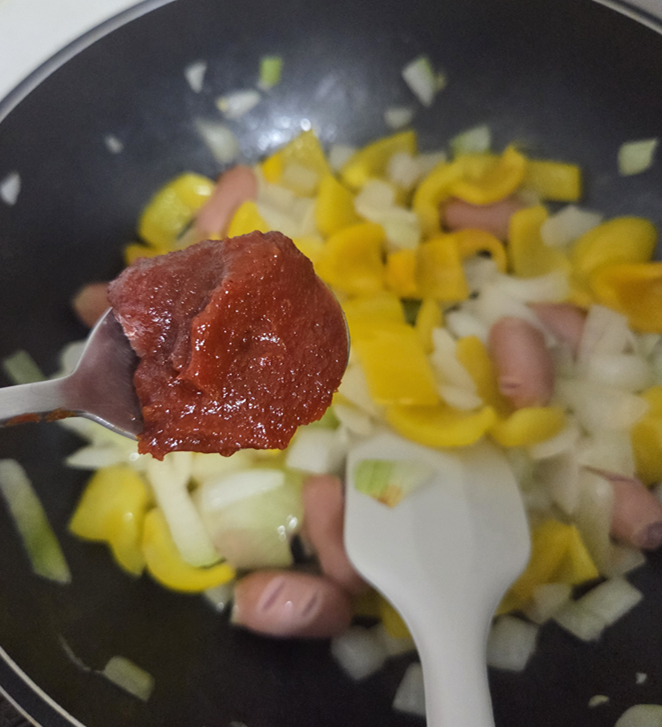 Adding gochujang and ketchup sauce to the sausage stir-fry