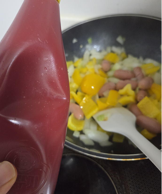 Adding gochujang and ketchup sauce to the sausage stir-fry